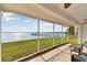 The screened patio overlooks the lush backyard and tranquil waterfront at 116 Shore Drive Pl, Oldsmar, FL 34677