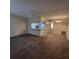 Open-concept living room featuring neutral carpet, light fixtures, and a view into the kitchen at 12760 Indian Rocks Rd # 540, Largo, FL 33774