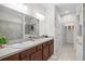 Bathroom featuring double sinks, a large mirror, tiled floors, and a walk-in shower at 13909 Galway Sand Rd, Riverview, FL 33579