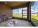 Screened lanai with comfortable seating and a serene view of the backyard and lake, perfect for relaxation at 13909 Galway Sand Rd, Riverview, FL 33579