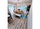 Dining area featuring a modern chandelier, wood table, and plantation shutters for natural light at 1420 Fairfield Dr, Clearwater, FL 33764