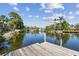 Wood dock overlooking calm waters, with lush greenery, palm trees, and waterfront homes creating a serene setting at 1516 Massachusetts Ne Ave, St Petersburg, FL 33703