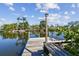 Scenic waterfront view from the wood dock, surrounded by lush landscaping and clear blue skies with calm waters at 1516 Massachusetts Ne Ave, St Petersburg, FL 33703