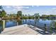 A wood dock extends into calm waters, offering scenic views of the surrounding waterfront properties and clear skies at 1516 Massachusetts Ne Ave, St Petersburg, FL 33703