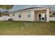 Large backyard with a covered patio and sliding glass doors to the home's interior at 1705 Bonita Bluff Ct, Ruskin, FL 33570