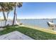A backyard with a well-maintained lawn, a dock, and scenic water views at 17821 Gulf Blvd # B, Redington Shores, FL 33708