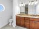 Bathroom featuring double vanity, large mirror, and a toilet at 17821 Gulf Blvd # B, Redington Shores, FL 33708