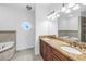 Bathroom featuring double vanity, a tub, and circular window at 17821 Gulf Blvd # B, Redington Shores, FL 33708
