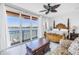 Bedroom featuring a decorative ceiling fan and waterfront views from sliding glass doors at 17821 Gulf Blvd # B, Redington Shores, FL 33708
