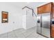 Tile floored kitchen with stainless steel refrigerator and staircase access at 17821 Gulf Blvd # B, Redington Shores, FL 33708