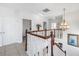 Bright foyer with wooden banister, chandelier, and neutral decor at 17821 Gulf Blvd # B, Redington Shores, FL 33708