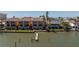 Scenic waterfront view of condos with dock, highlighting serene coastal living at 17821 Gulf Blvd # B, Redington Shores, FL 33708