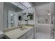 Clean bathroom featuring vanity with mirror and tiled floor leading to a bright bedroom at 1992 S Belcher Rd, Clearwater, FL 33764