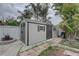 A well-maintained storage shed with double doors and decorative shutters sits in the backyard at 1992 S Belcher Rd, Clearwater, FL 33764