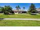 Well-maintained home with a lush green lawn and screened-in lanai overlooking the backyard at 2426 Sifield Greens Way, Sun City Center, FL 33573