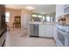 Bright kitchen connects to dining and living areas, featuring stainless steel appliances and light wood floors at 2426 Sifield Greens Way, Sun City Center, FL 33573