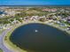 An aerial view showcasing a community pond and the surrounding neighborhood at 26 Clintwood Ave, Englewood, FL 34223