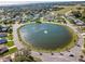 High-angle shot showing a community's circular pond, homes, and green spaces, highlighting the area's serene environment at 26 Clintwood Ave, Englewood, FL 34223