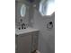 Bathroom featuring updated vanity with black hardware, sleek countertop, and framed octagon window at 26 Clintwood Ave, Englewood, FL 34223