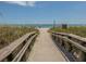 Inviting beach access with wooden boardwalks leading to a sunny beach with blue waters at 26 Clintwood Ave, Englewood, FL 34223
