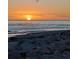 Picturesque sunset over the ocean with rocky beach foreground and a bird flying overhead at 26 Clintwood Ave, Englewood, FL 34223