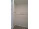 Interior closet with modern white walls and a wooden floor and hanging rod at 26 Clintwood Ave, Englewood, FL 34223