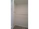 A small closet with gray wood-look flooring and white shelving at 26 Clintwood Ave, Englewood, FL 34223