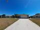Single-story home with a spacious driveway, lush landscaping, and a well-maintained lawn at 26 Clintwood Ave, Englewood, FL 34223