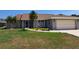 Charming single-story home featuring a two-car garage, screened entryway, and lush landscaping at 26 Clintwood Ave, Englewood, FL 34223