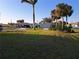 Single-story home with attached garage, lawn, and palm trees under a clear blue sky at 26 Clintwood Ave, Englewood, FL 34223