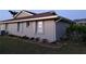 Side view of a single-story home featuring a well-maintained yard and brick-lined garden bed at 26 Clintwood Ave, Englewood, FL 34223