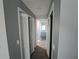 Hallway featuring gray walls, white trim, and doors that lead to the bathroom at 26 Clintwood Ave, Englewood, FL 34223