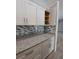 Kitchen showcasing white cabinets, granite countertops, and stylish backsplash, blending beauty and functionality at 26 Clintwood Ave, Englewood, FL 34223