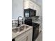 Charming kitchen featuring granite countertops, sleek black appliances, and modern fixtures at 26 Clintwood Ave, Englewood, FL 34223