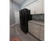 A view of the kitchen featuring a black refrigerator, granite countertops, and white cabinets at 26 Clintwood Ave, Englewood, FL 34223