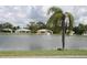 Scenic pond view featuring a fountain, palm trees, and the serene surroundings of lakeside houses, promoting a tranquil lifestyle at 26 Clintwood Ave, Englewood, FL 34223