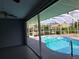 View from the enclosed patio looking out to a beautiful in-ground pool with a screened enclosure at 26 Clintwood Ave, Englewood, FL 34223