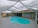 Aerial view of screened-in pool and spa with an attached patio area at 26 Clintwood Ave, Englewood, FL 34223