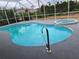 Inviting pool with a safety handrail and hot tub, enclosed in a screen for bug-free enjoyment at 26 Clintwood Ave, Englewood, FL 34223