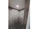 Walk-in shower with gray tile, pebble flooring and modern fixtures at 26 Clintwood Ave, Englewood, FL 34223