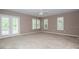 A carpeted bedroom with neutral colored walls, a ceiling fan, and French doors to a balcony at 2880 Bayshore Trails Dr, Tampa, FL 33611