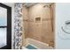 This full bathroom features decorative wall tiles and a shower-tub combination at 3442 Beech Trl, Clearwater, FL 33761