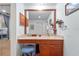 Vanity with wood frame mirror, lighting, flower decorations, stool and cabinet space below counter at 3442 Beech Trl, Clearwater, FL 33761