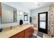A full bathroom with double sinks, vanity, and a door to the backyard, perfect for convenience at 3442 Beech Trl, Clearwater, FL 33761