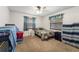 A tidy bedroom with neutral carpet, a ceiling fan, and two windows with curtains is move-in ready at 3442 Beech Trl, Clearwater, FL 33761