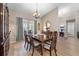 Dining area with a wooden table set, chair coverings, chandelier, and a large front-facing window at 3442 Beech Trl, Clearwater, FL 33761