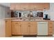 Kitchen sink and cabinets overlooking into an adjacent living room with a fireplace at 3442 Beech Trl, Clearwater, FL 33761