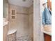 The bathroom features tile walls, a built-in nook for bath products, a seat and pebble-stone shower floor at 3442 Beech Trl, Clearwater, FL 33761