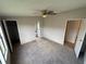 Bedroom with neutral carpet, ceiling fan, and multiple closets and doorways at 37542 Pinata Ave, Zephyrhills, FL 33541