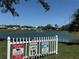 Community scene with a lake, fountain, and security notice at the entrance at 37542 Pinata Ave, Zephyrhills, FL 33541